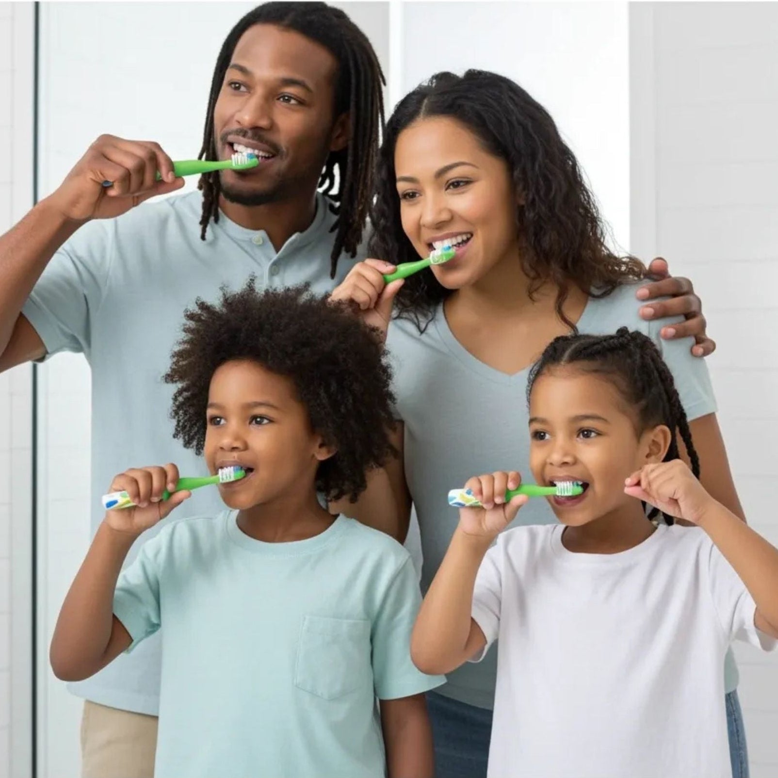 Family of four brushing their teeth together in a bathroom setting